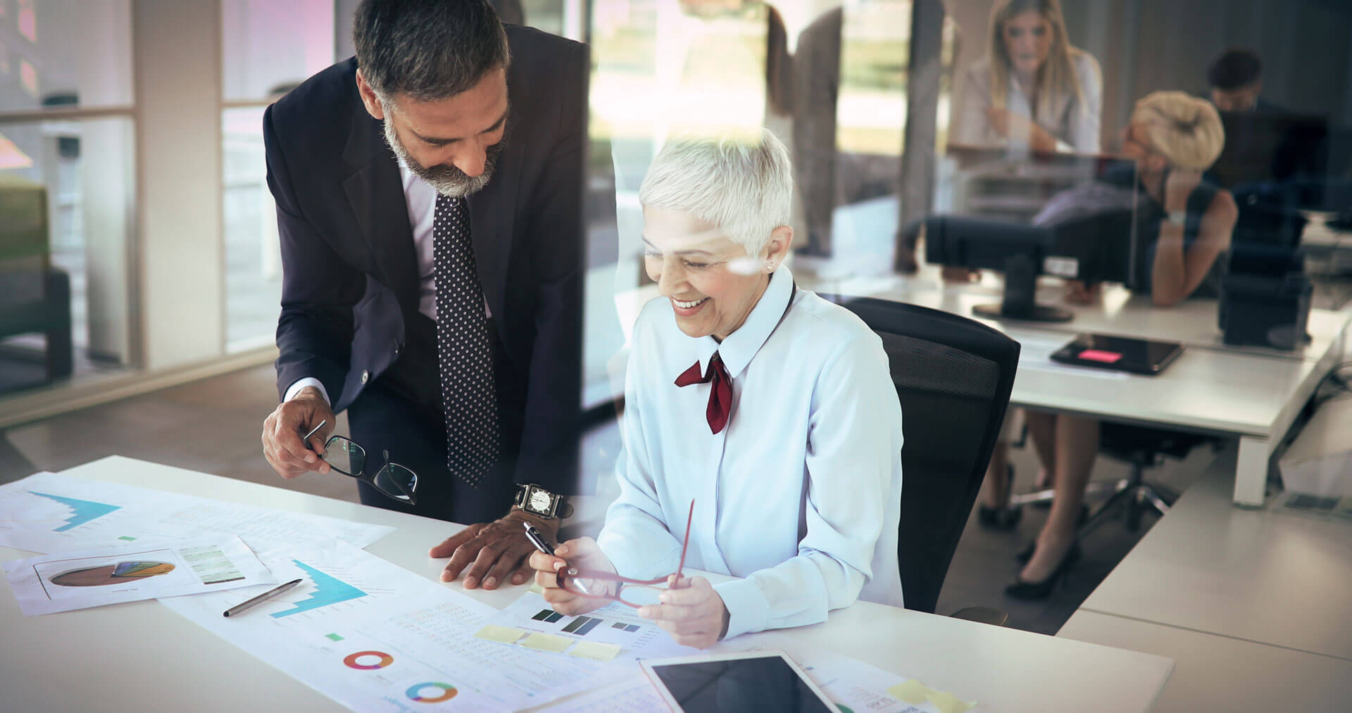 man and woman looking over business charts on paper