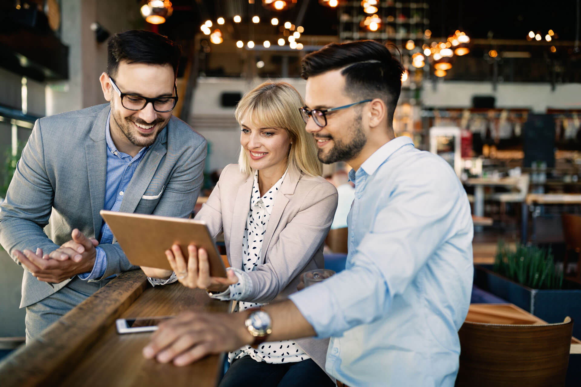 three people looking at laptop