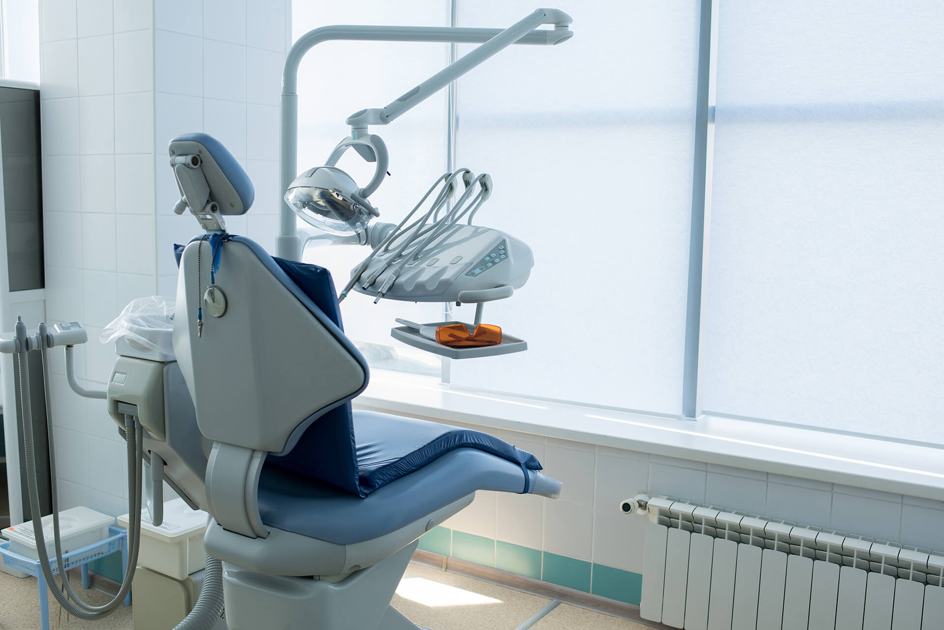 Blue colored seat and working objects of dentist placed in light modern office