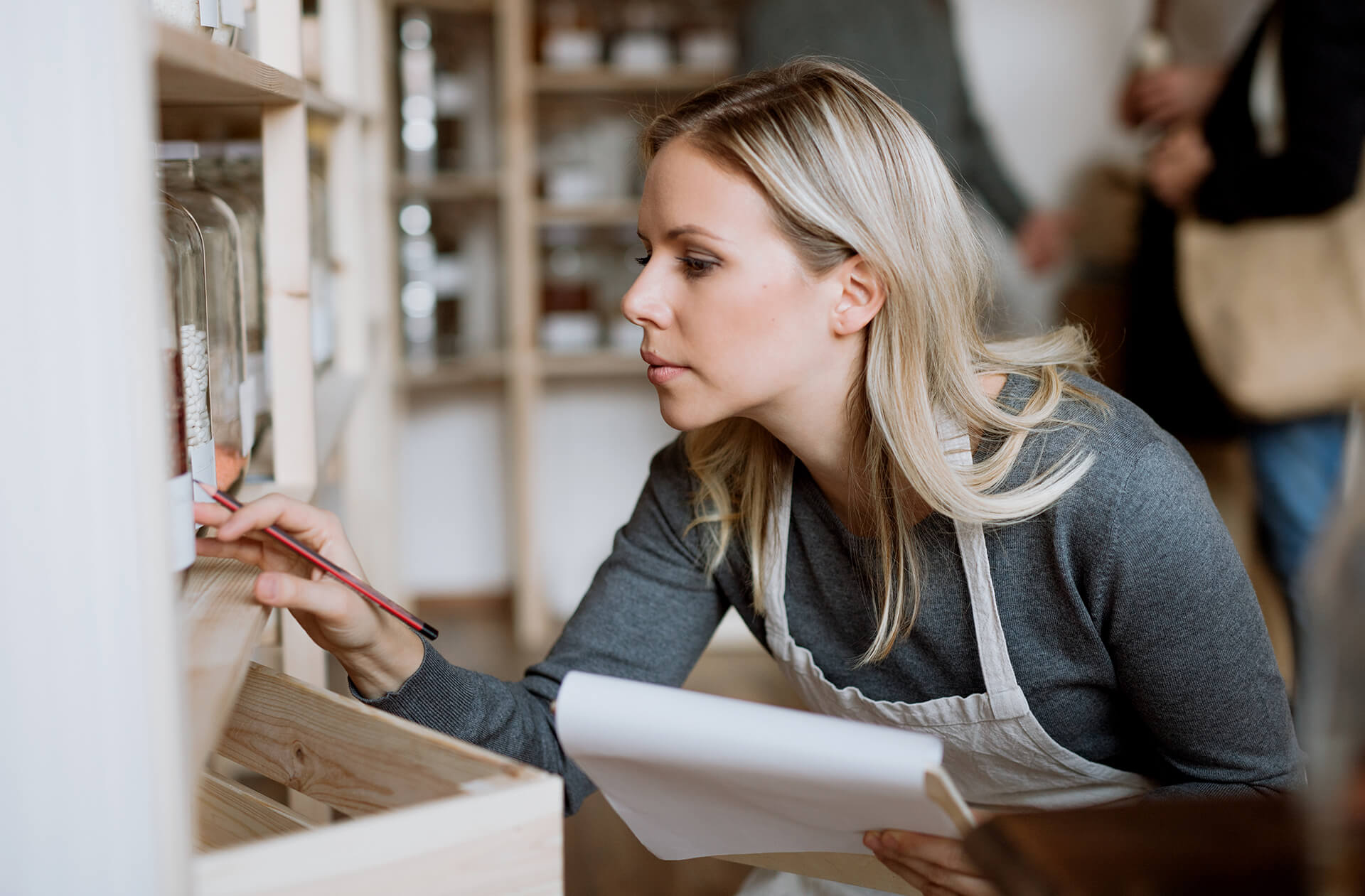 A female shop assistant working in a zero-waste shop.